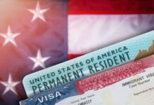 Green card and visa with U.S. flag background.