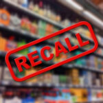 SHOCKING Defect Forces Historic Truck Recall.. Recall sign over blurred grocery store shelves
