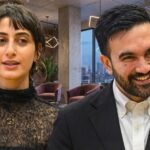 MAMDANI BUSTED Using Mansion For Radical Campaign… Two professionals engaged in conversation in a modern office setting