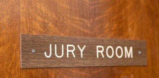 Jury room sign on wooden door.