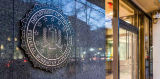 FBI seal on building wall near entrance doors.