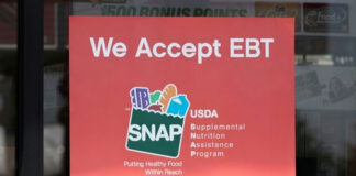 Red sign on a storefront window announcing acceptance of EBT and SNAP benefits