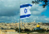 Israeli flag waving in front of the Jerusalem skyline with a golden dome in view