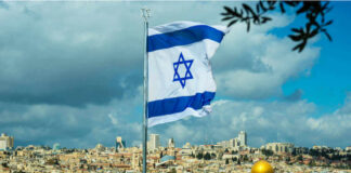 Israeli flag waving in front of the Jerusalem skyline with a golden dome in view
