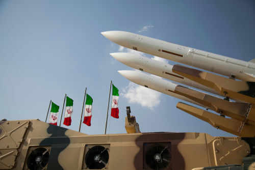 shutterstock1621002841-2jpg Missiles on launchers beside Iranian flags.
