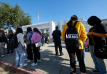 DOJ Heat Hits Defiant School Districts Students standing outside a high school entrance