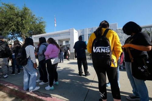 shutterstock_2190331639 Students standing outside a high school entrance