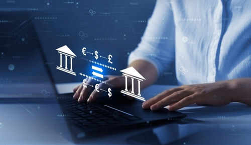 shutterstock_2284207331 Person typing, banking and currency exchange symbols displayed.