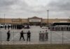 Law enforcement officers and detainees outside a secure detention facility at a Walmart location